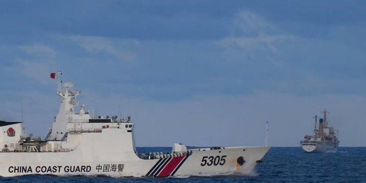 Imagen de una embarcación de la Guardia Costera de China se aproxima a un navío filipino (R), integrante de un grupo de barcos civiles, en las aguas contenciosas del Mar de China Meridional, fecha 10 de diciembre de 2023. (Foto de TED ALJIBE / AFP)