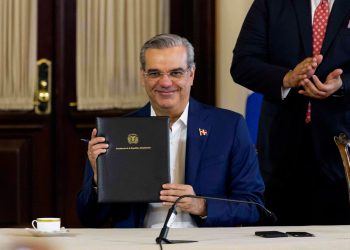 Foto del presidente Luis Abinader mientras firma decréto que regula la publicidad estatal.